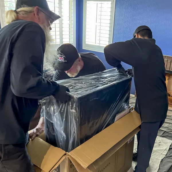 The crew unboxing a new fireplace insert inside a home